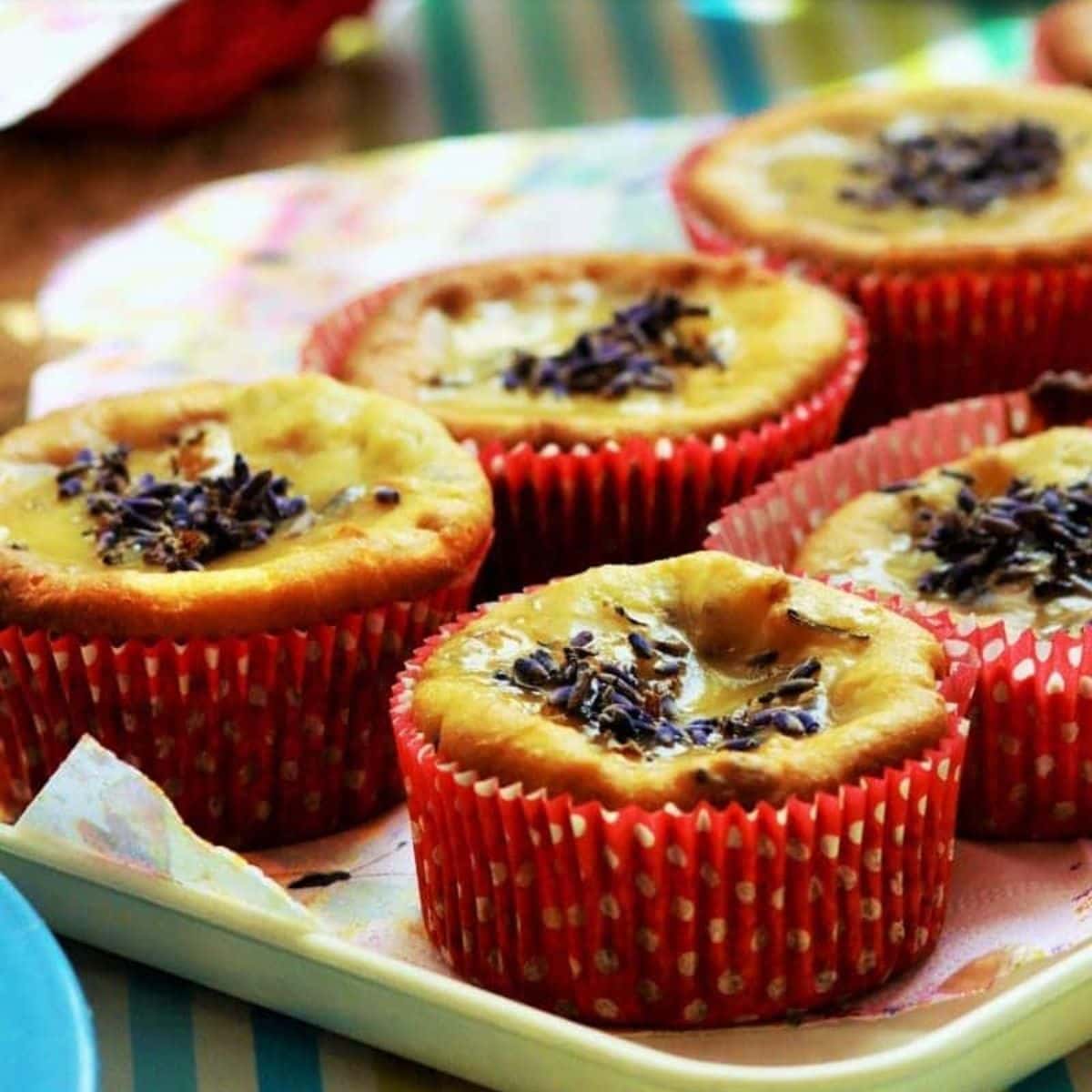 Four baked cupcakes in red polka dot wrappers sit on a tray, topped with chocolate sprinkles—perfect for adding a sweet touch to your collection of muffin tin dinner recipes.