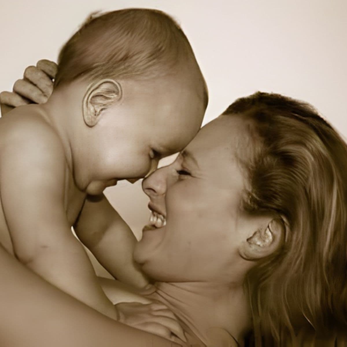 A woman holds a smiling baby close, their foreheads touching as they share a joyful moment—capturing the love that inspires thoughtful Mother's Day gift ideas.