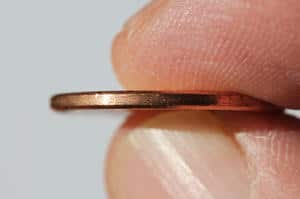 two fingers holding a penny