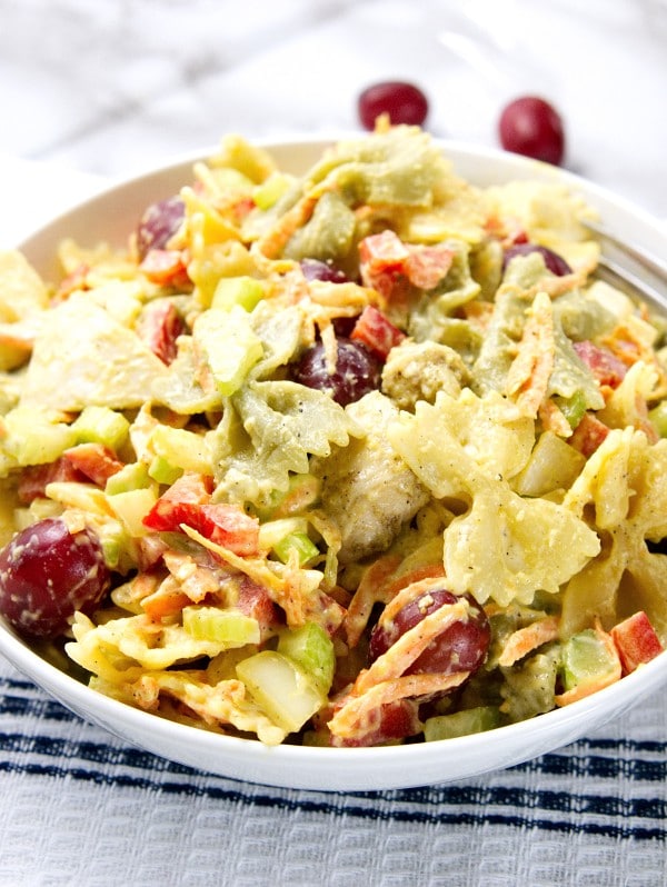 close up of Chicken Pasta Salad in a white bowl on a white cloth on a gray kitchen counter