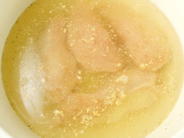 chicken breasts in chicken stock in a pot