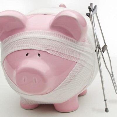 Piggy bank wrapped in gauze and crutches next to it