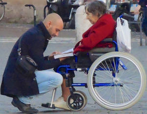 Man helping woman in wheelchair