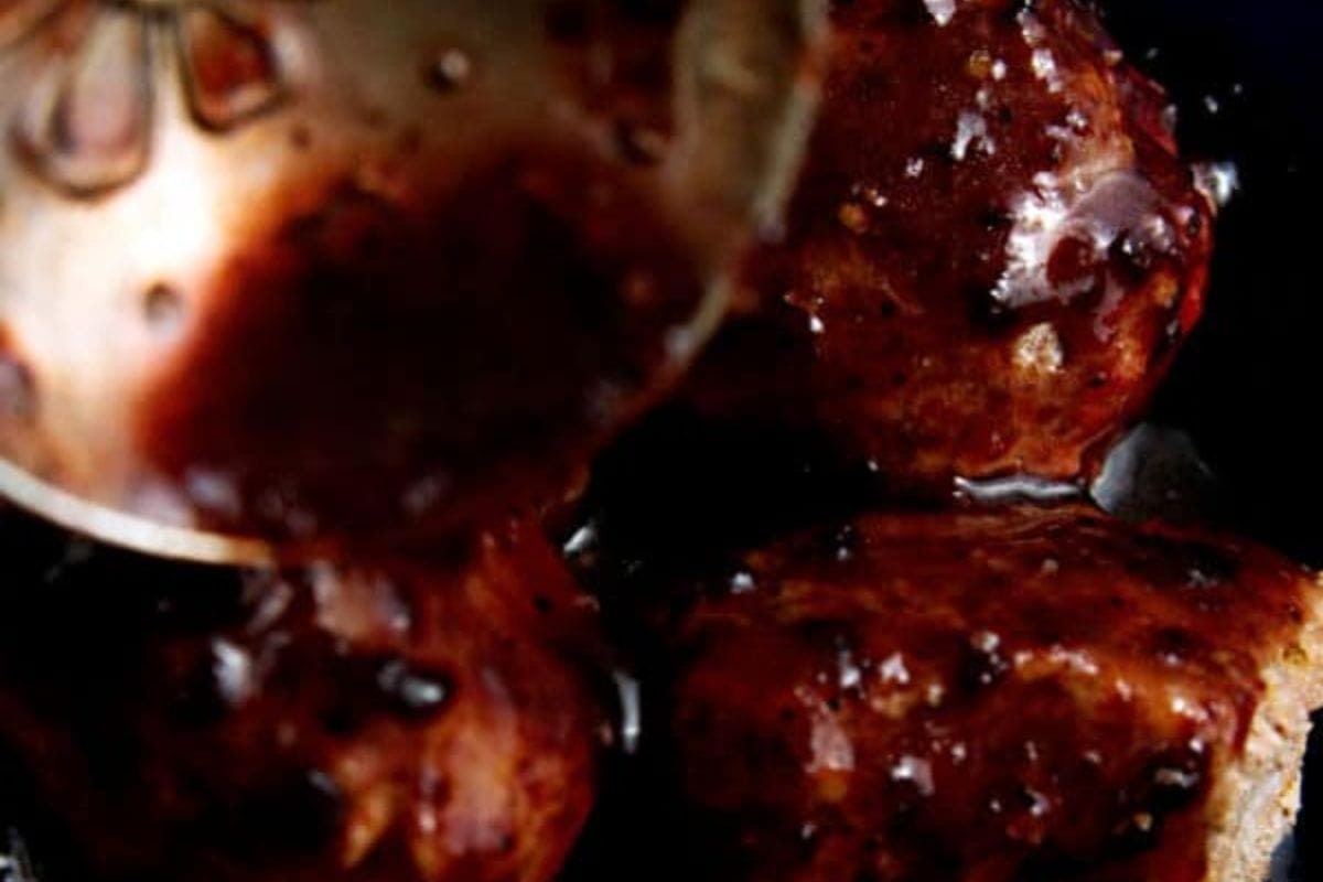 pouring sauce over meatballs.