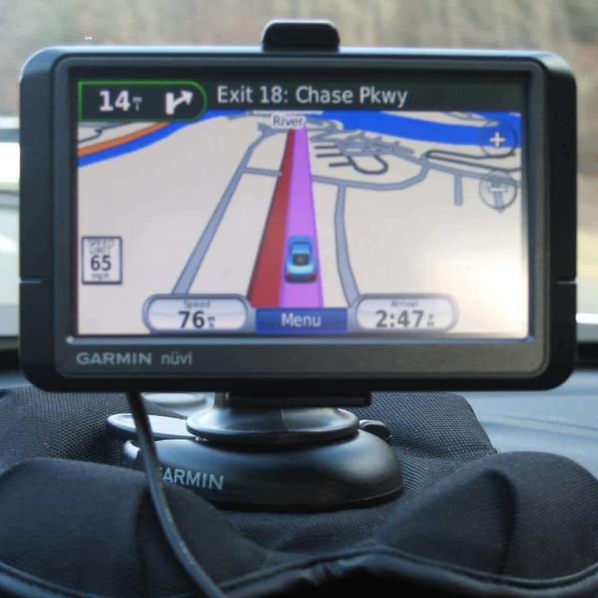 A Garmin GPS device displays directions for Exit 18: Chase Parkway during a road trip, showing a speed of 76 mph and the time as 2:47.