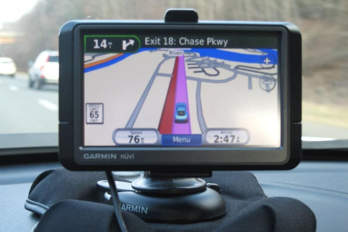 A Garmin GPS device on a car dashboard displays driving directions toward Exit 18: Chase Pkwy, showing speed, time, and the surrounding road map-perfect for staying on track during your next road trip.