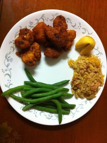 Easy General Tso Chicken next to green beans, fried rice, and a fortune cookie on a white plate