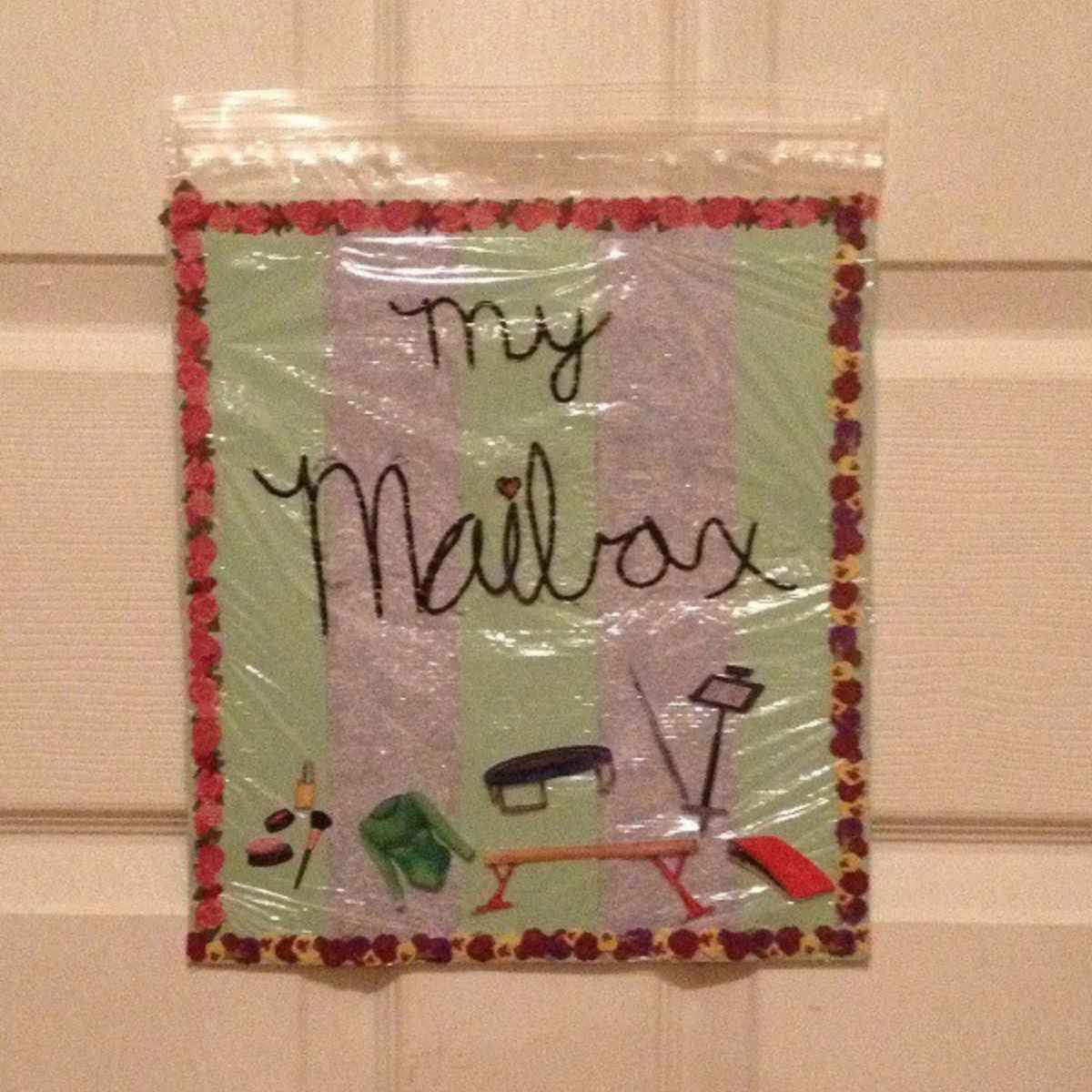 A decorated plastic bag labeled "my Mailbox" with images of mail-related items is taped to a door, offering a fun twist on family mailboxes for organizing personal notes or messages.