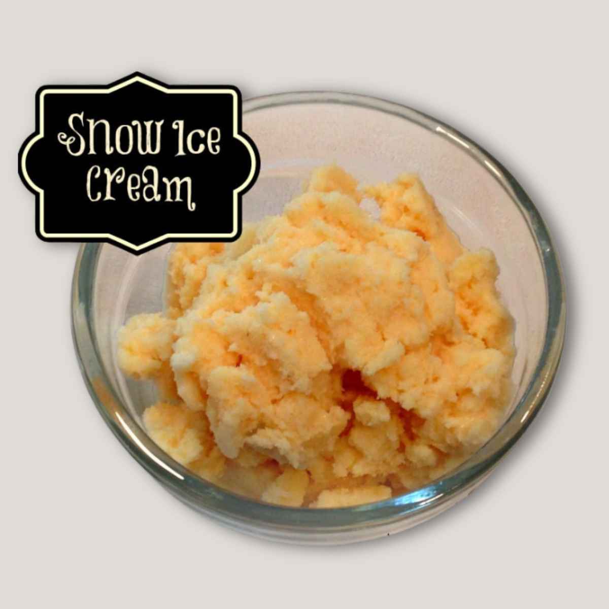 A glass bowl filled with creamy yellowish snow ice cream, topped with a label that reads "Snow Ice Cream" in decorative text.
