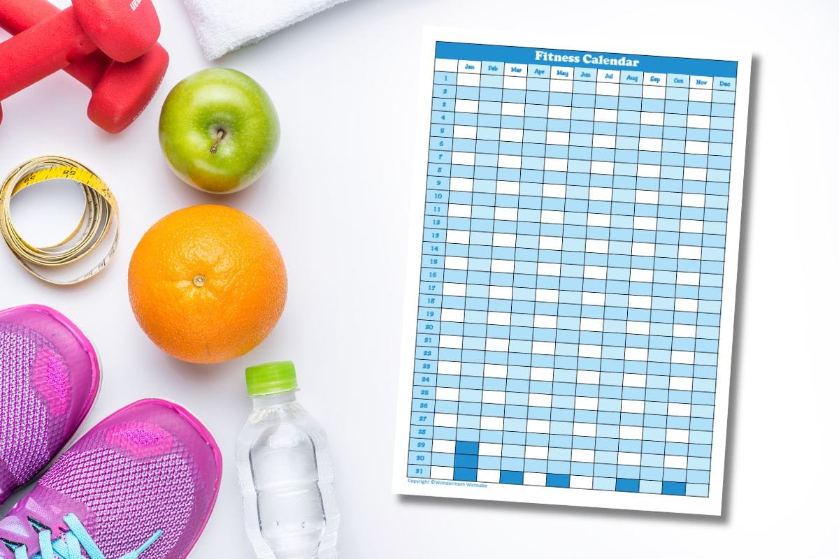 A fitness calendar with workout essentials on a white surface.