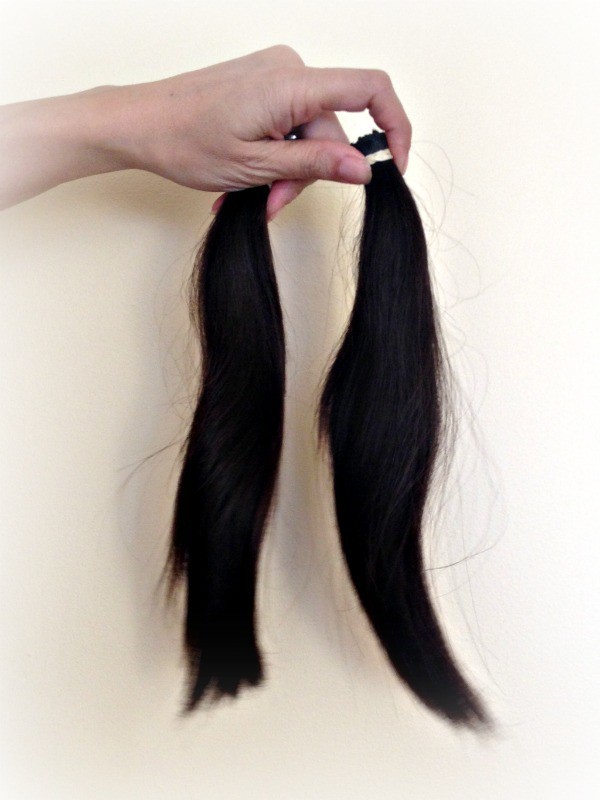 a handing holding two Ponytails of hair 