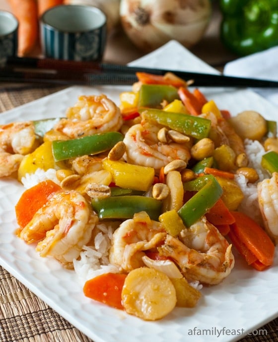 Sweet and Sour Shrimp Stir Fry on a white plate with black chopsticks on it
