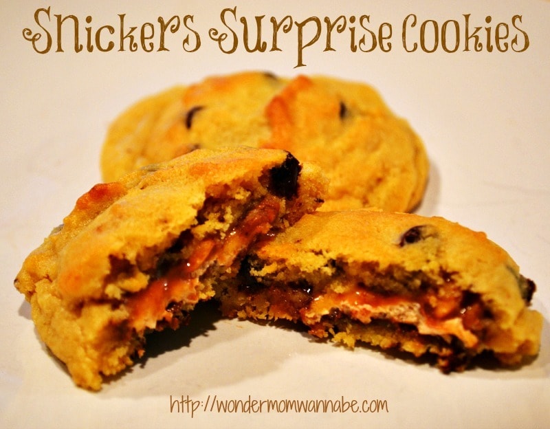 three cookies on a tan background with title text reading Snickers Surprise Cookies