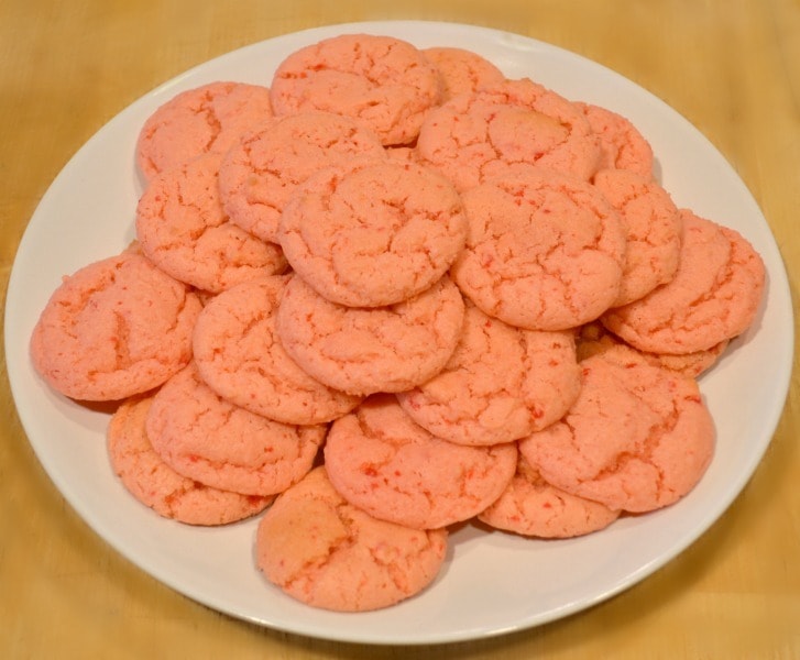 Strawberry Cake Mix Cookies on a white plate on a brown table