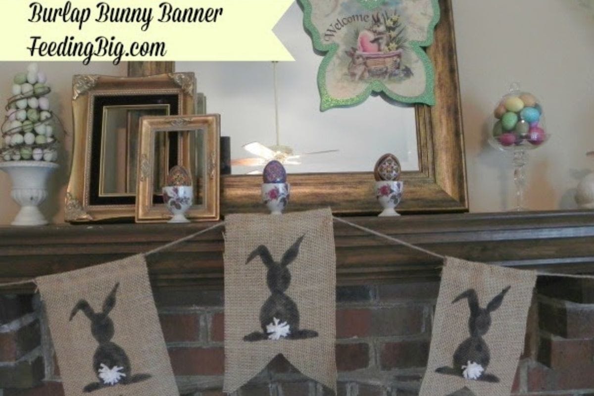 A burlap banner with black bunny silhouettes hangs on a brick mantel.