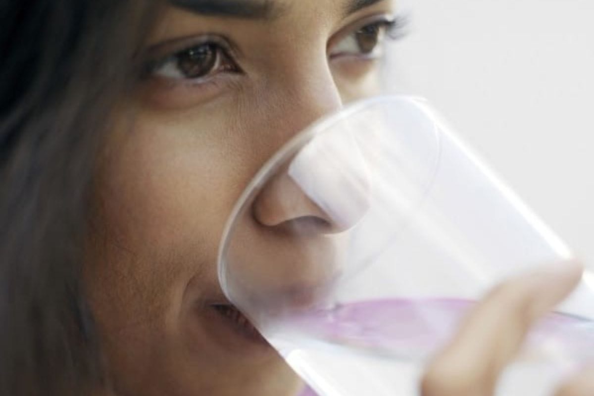 a lady drinking a glass of water.