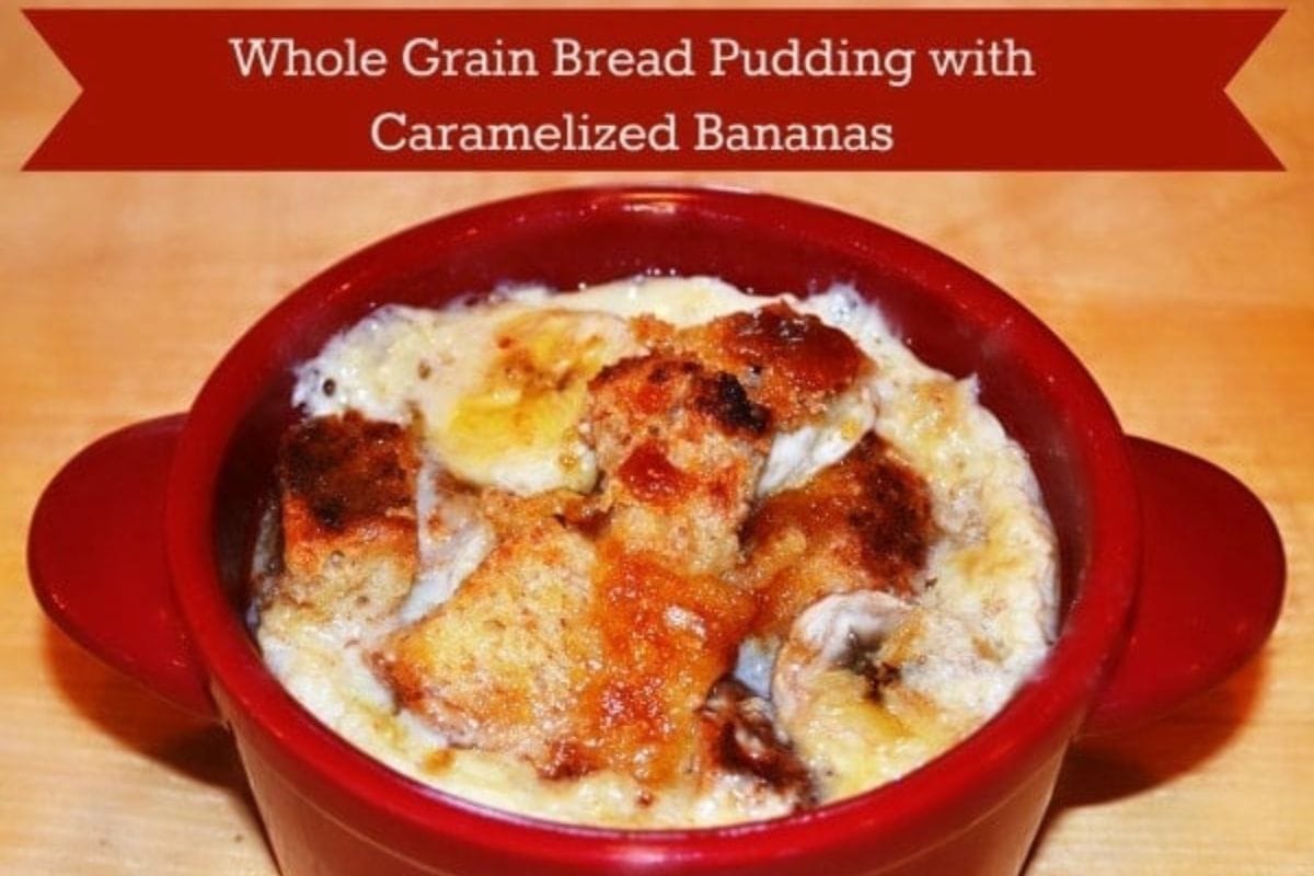 A red ramekin filled with whole grain Roman Meal bread pudding, sits on a wooden surface.