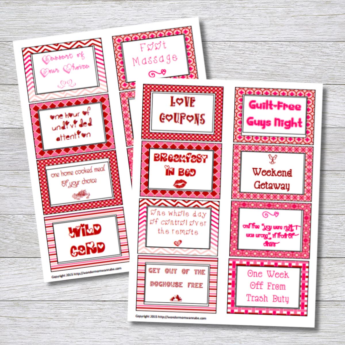 Two sheets of free printable love coupons with red and pink borders, featuring rewards like breakfast in bed, foot massage, and guilt-free guys night, displayed on a wooden surface.