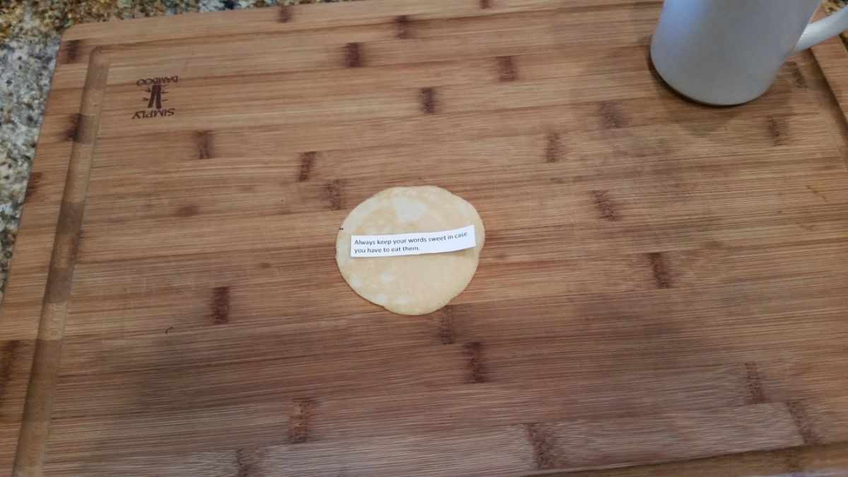 Cookie with fortune on a chopping board