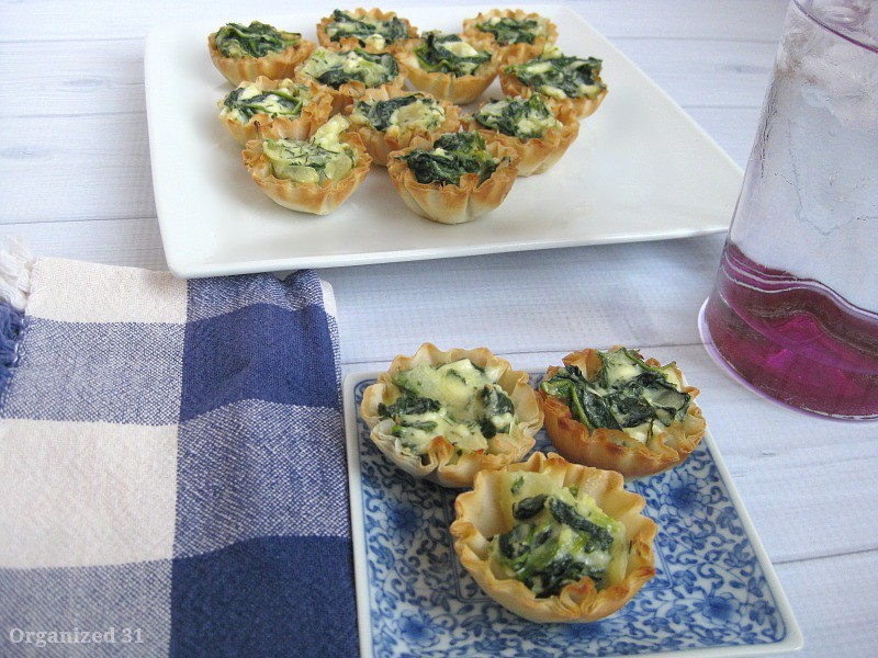 spinach feta pie appetizers on a blue plate and on a white plate on a wood table