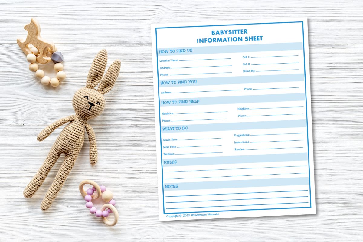 A blank babysitter information sheet on wooden surface, surrounded by a crocheted bunny toy, teether, and pacifier clip.