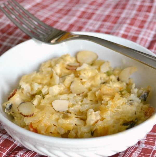 Creamy Garden Chicken Casserole in a white bowl with a fork on it on a red and white checkered cloth