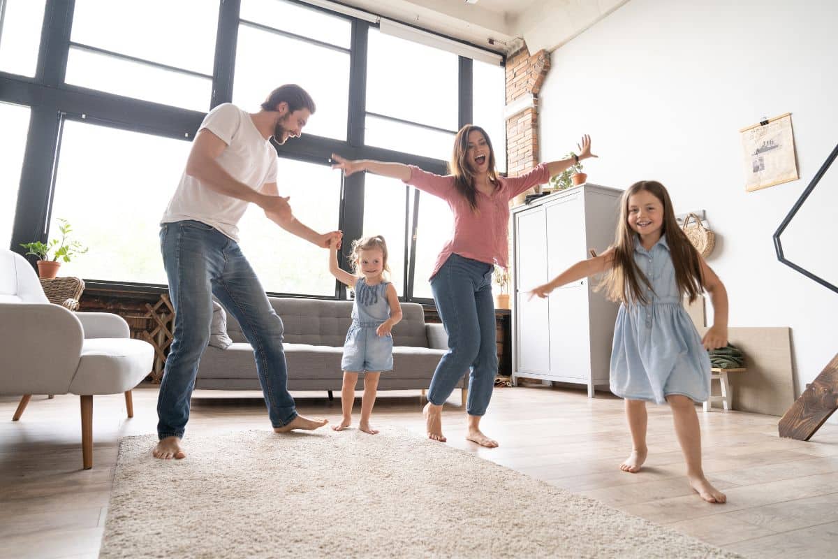 A family is dancing in a living room.