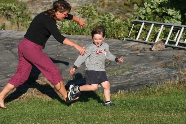 a mom and son running outside and playing tag as one of the Games You Can Play With Your Kids Instead of Exercising