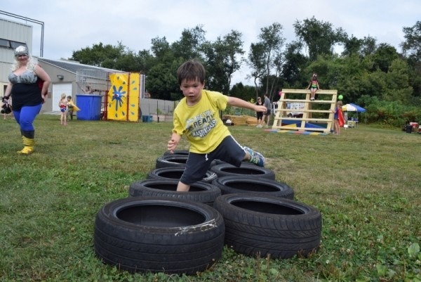 a young boy going through a tire obstacle course