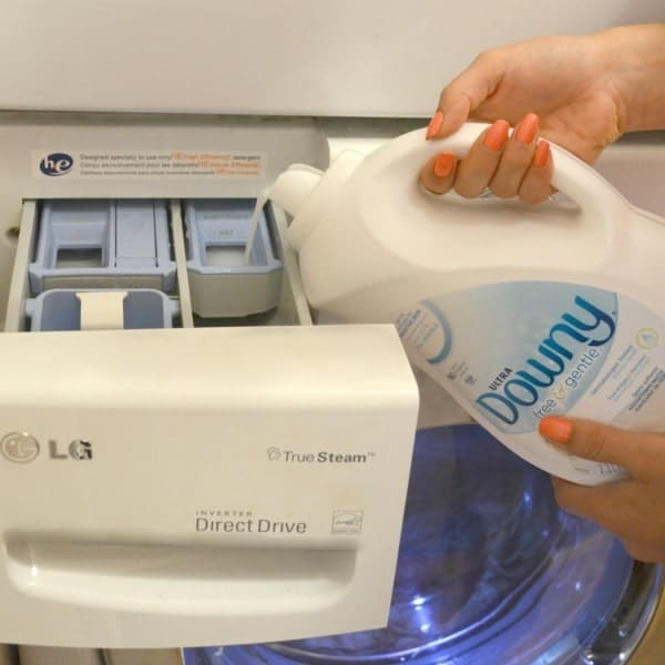 Bottle of Downy Free & Gentle Fabric Softener being poured into washer