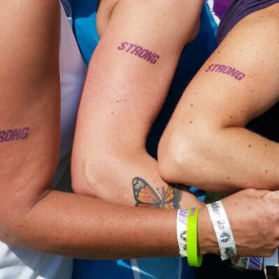 3 women flexing their arms with strong written in purple