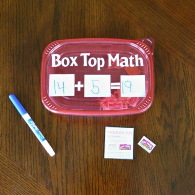 Plastic container that says box top math. 14 + 5 = 19