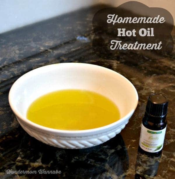 oil treatment in a white bowl next to a jar of essential oil with title text reading Homemade Hot Oil Treatment