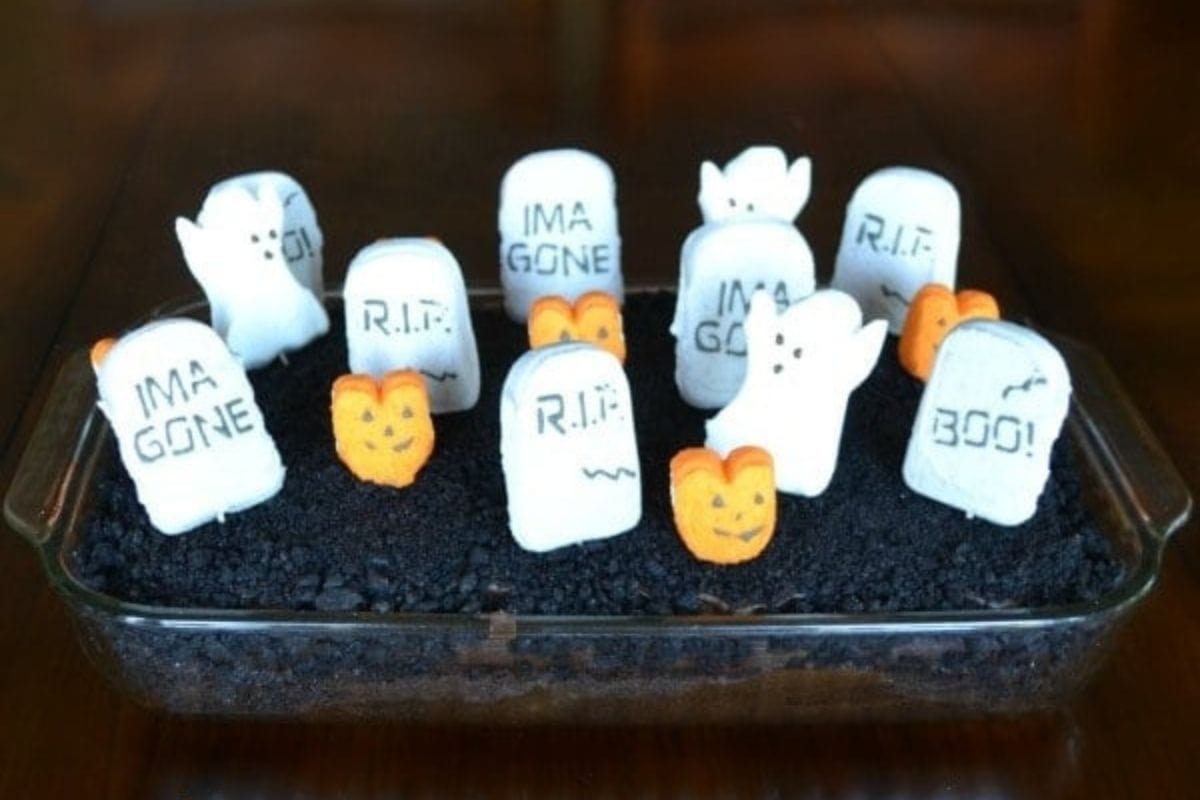 Graveyard Cake decorated with marshmallow grave markers and pumpkins.