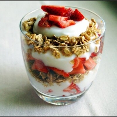 Yogurt parfait with oats and strawberries, in glass cup