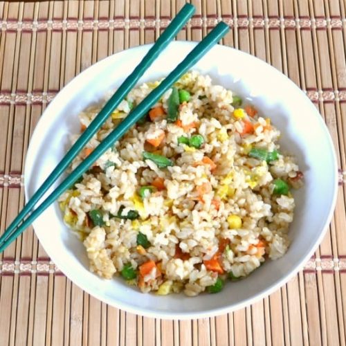 Veggie Fried Rice in white bowl with blue chopsticks