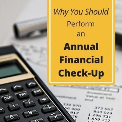 A calculator and pen rest on financial documents beside a sign that reads, "Why You Should Perform an Annual Financial Check-Up," highlighting the importance of regularly assessing your finances.