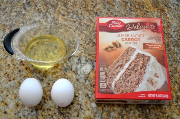 Easter Cake Mix Cookie Ingredients: two eggs, measuring cup of oil, box of carrot cake mix, all on a counter