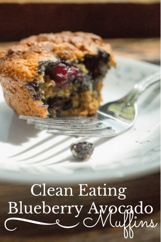 blueberry avocado muffin on a white plate with a fork on it with title text reading Clean Eating Blueberry Avocado Muffins
