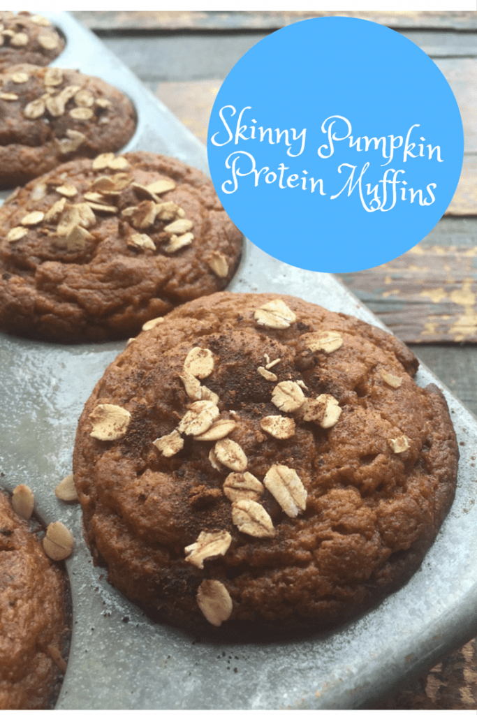 pumpkin protein muffins in a gray pan on a wood tale with title text reading Skinny Pumpkin Protein Muffins