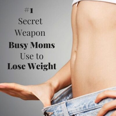 A close-up of a person in loose jeans, exposing their midriff, with text revealing the secret weapon busy moms use to lose weight.