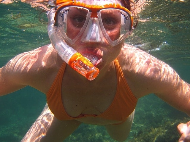 a girl snorkling at a swimming hole