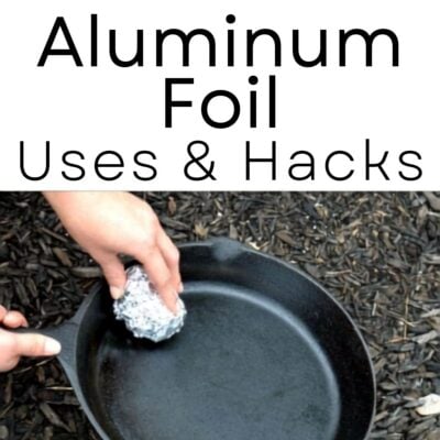 Hands scrubbing a cast iron pan with a ball of aluminum foil over a mulch surface; text above reads "Aluminum Foil Uses & Hacks" to showcase creative aluminum foil uses for cleaning.