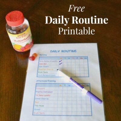 A bottle of multivitamins, a purple pen, and a filled-in kids daily routine printable checklist are on a wooden table.