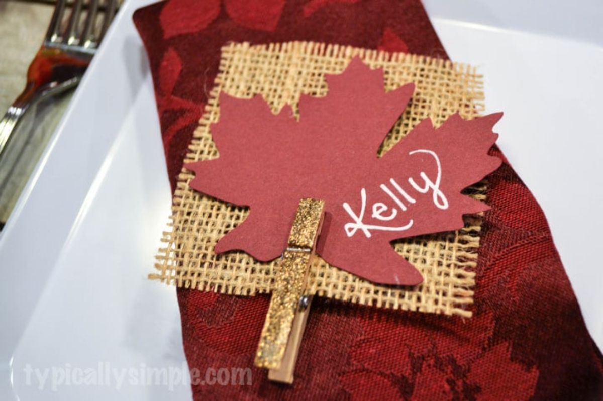 An easy Thanksgiving decor idea featuring a place card with a red maple leaf on it.