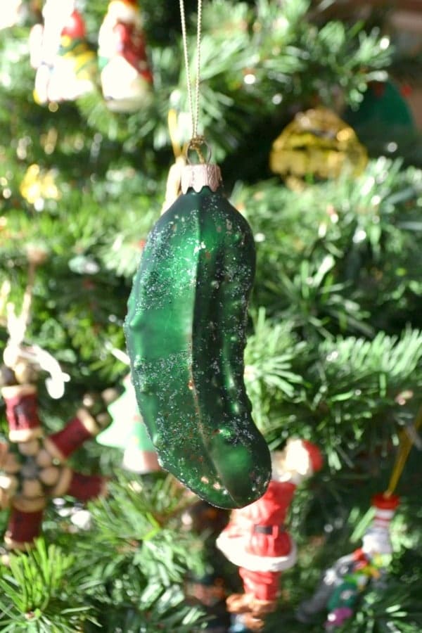 a closeup of a pickle ornament hanging from a Christmas tree