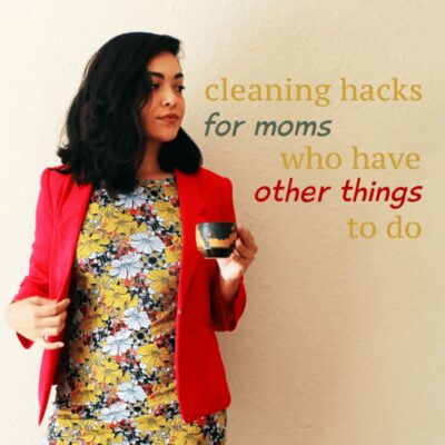 Woman in a floral dress and red blazer holding a cup, with text: "cleaning hacks for moms" on a plain background. Perfect tips for busy moms who want quick and easy solutions for a tidier home.