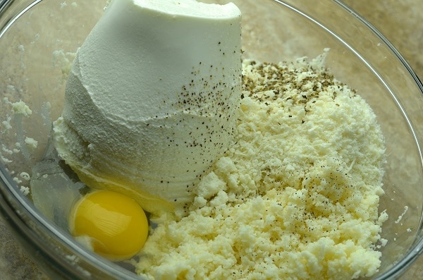 cheeses, egg and seasonings in a glass bowl