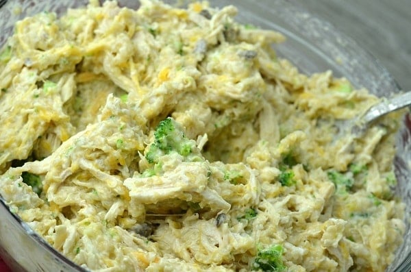 chicken, broccoli, quinoa, cream of mushroom soup, cheddar cheese, milk, and garlic powder in a glass dish