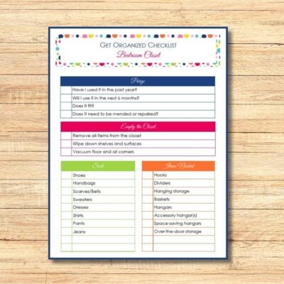A get organized checklist for your bedroom closet, featuring sections to purge, empty the closet, sort items, and find storage solutions—perfectly displayed on a wooden surface.
